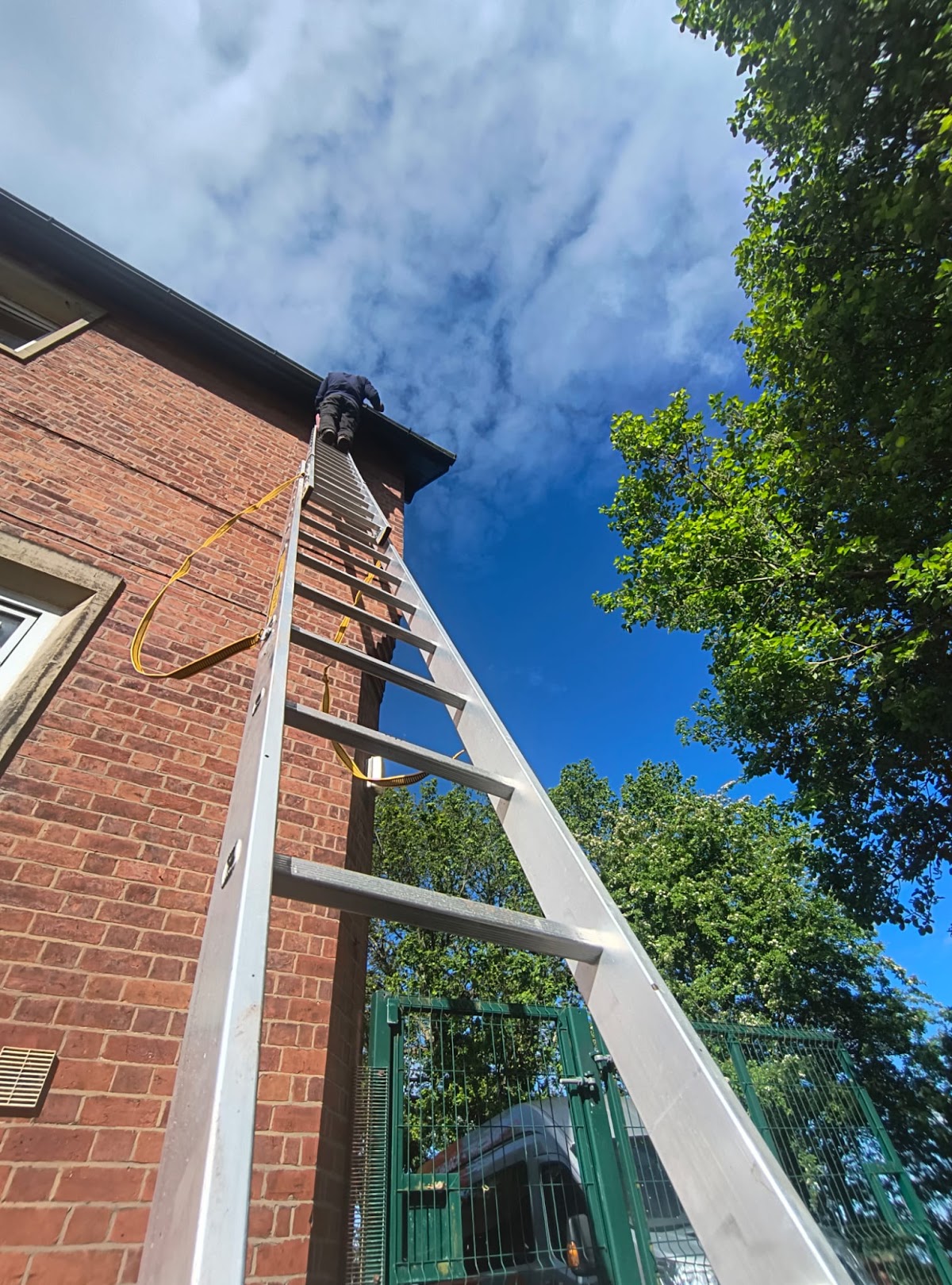 F P Turner working from a ladder at the roofline